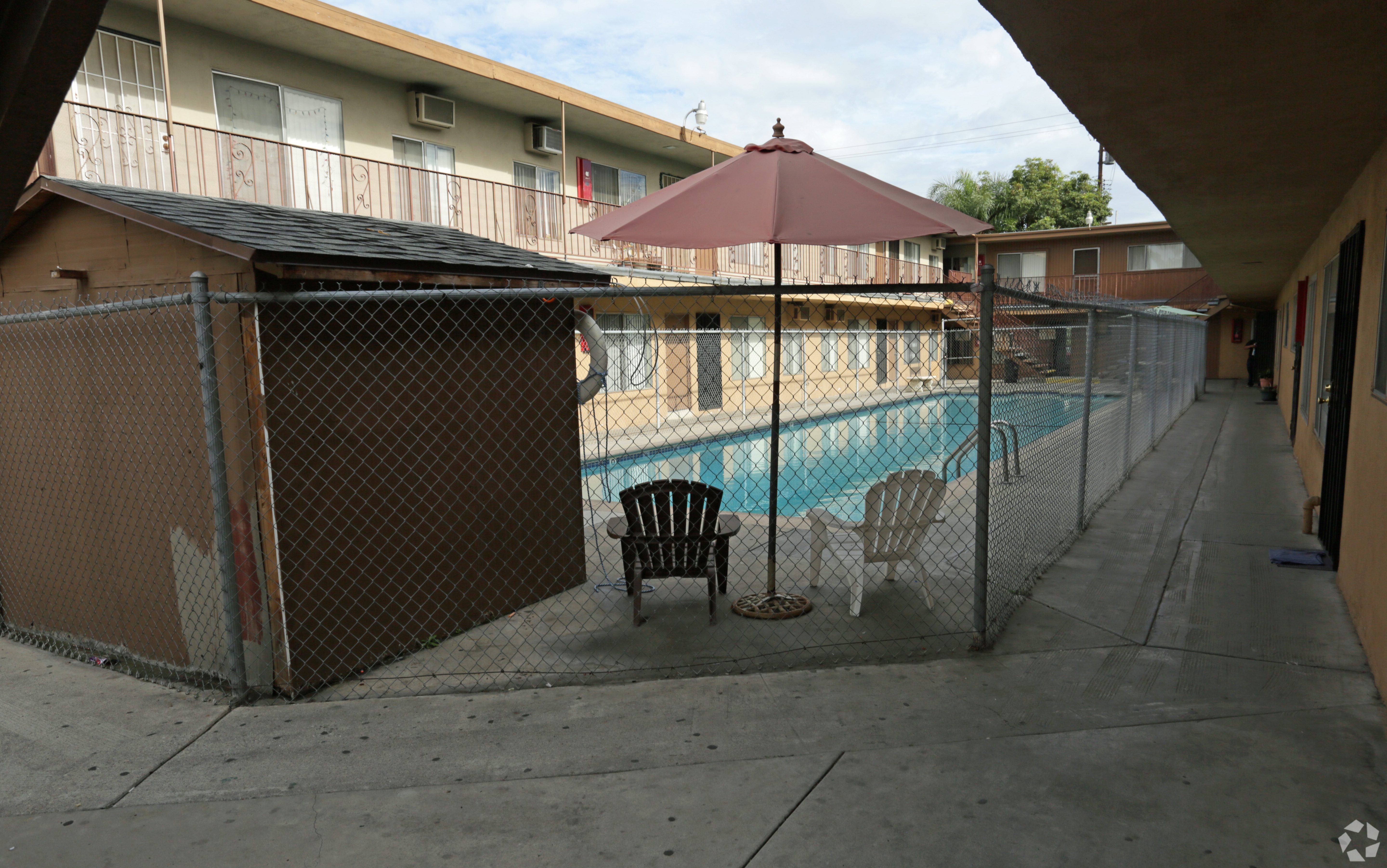 A pool with a fence and a chair.